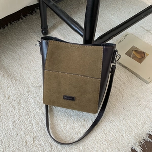 Détail du sac seau vert olive avec patchwork en cuir et étiquette NO FILTER brodée