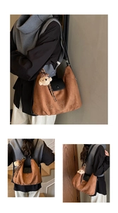 Detail view of retro brown suede tote bag with cartoon embroidery and teddy bear charm