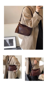 Détail d'un sac à bandoulière demi-lune marron foncé avec pompon et texture cuir ciré