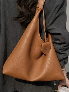 Brown lychee leather tote bag with unique triangle structure and lock pendant detail