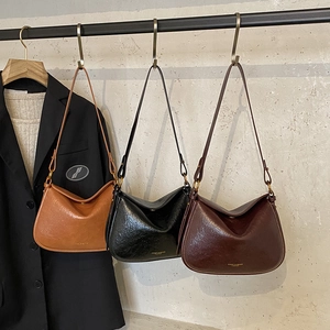 Détail des sacs portés épaule demi-lune en cuir brillant ciré noir et marron vintage