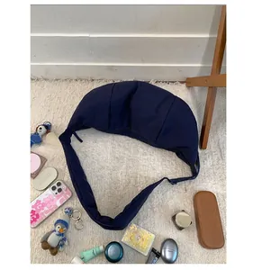 Detailed view of dark blue padded nylon crescent bag on a white faux fur surface