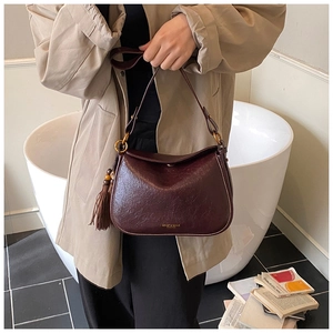 Détail du sac hobo bordeaux avec texture cuir vintage et élégant charme à franges