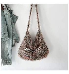 Dettaglio della borsa hobo in peluche con ricamo fun party bianco e texture vintage con nappe