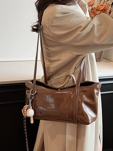 Polished coffee brown faux leather underarm tote bag with a baseball charm and logo