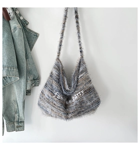 Dettaglio della borsa tote in peluche con ricamo fun party e trama blu-grigio