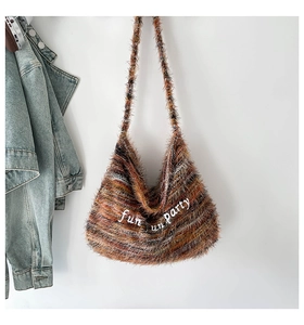 Dettaglio della borsa hobo a righe marroni pelose con ricamo bianco fun fun party