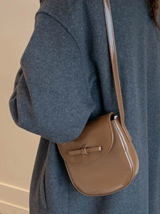 Retro brown glossy patent leather crossbody bag with a curved minimalist half-moon shape