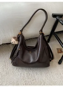 Detail view of the brown vintage hobo bag with teddy bear charm and front zipper