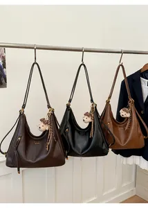Three leather hobo shoulder bags in brown and black with bear charms on hooks