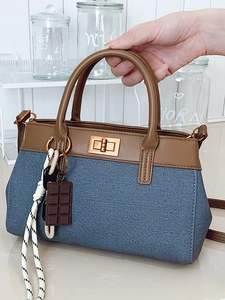 Blue denim and brown leather bucket handbag with stylish metal twist lock and shoulder strap
