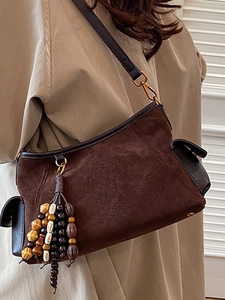 Brown suede half-moon crossbody bag with bohemian beaded tassel and adjustable strap