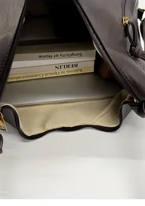 Detail view of large brown leather tote interior with beige lining and storage space