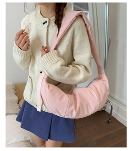 Detail of pink quilted nylon croissant bag with wide shoulder strap and pleated texture