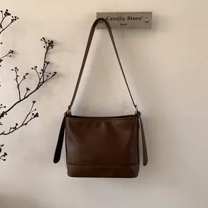 Detailansicht der verstärkten Bodennähte und der dunkelbraunen Leder-Schultertasche