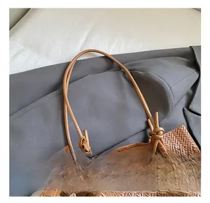 Detail of caramel brown woven tote bag featuring artisan hand-knotted rope handle design