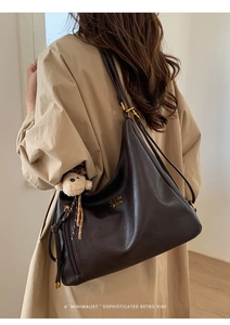 Detailed back view of a large dark brown faux leather tote bag with a plush bear charm