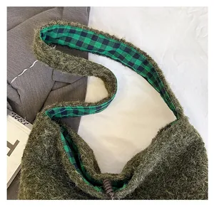 Detail view of plush dark green faux mohair shoulder bag with plaid lining and bead closure