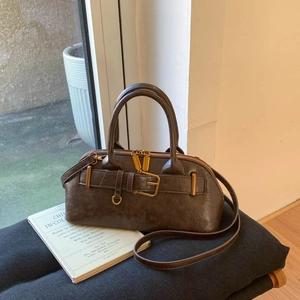 Detail of vintage brown leather handbag with gold metal clasp and dual zipper