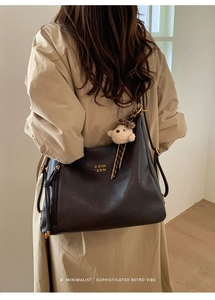 Detailed side view of deep brown retro tote bag with adjustable strap and bear charm