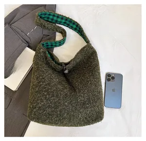 Detail view of green fleece hobo bag with plaid lining and leather zip puller