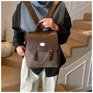 Detailansicht Vintage-Rucksack mit braunen Lederriemen und Aufnäher im College-Stil
