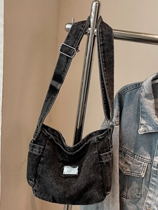 Vintage black washed denim crossbody bag with adjustable strap and metal tag detail