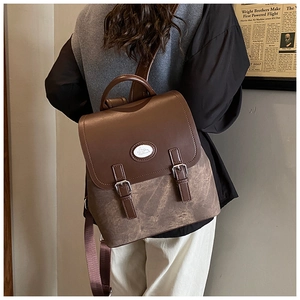 Retro-Rucksack aus braunem Leder und Canvas am Modell mit Klappe und Doppel-Schnallen