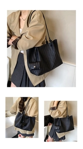 Detailed close-up of a black woven tote bag with a small matching purse and shoulder straps