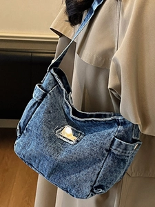Retro denim shoulder bag in snowflake wash featuring vintage frayed edges and side pockets