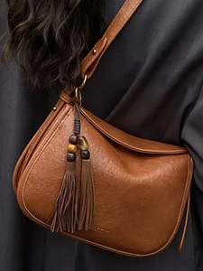 Sac à bandoulière vintage marron en similicuir avec pompon décoratif et texture