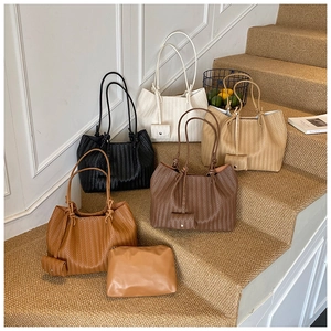 Multiple colors of woven tote bags showing high-quality V-pattern textures and textures