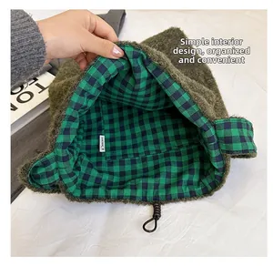 Detail showing the green fleece fabric exterior and green checkerboard lining of the tote bag