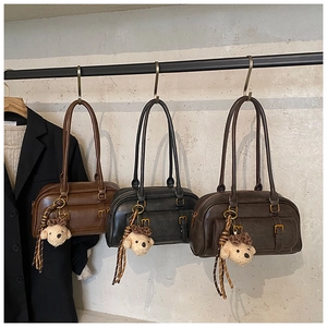 Three vintage leather bowling bags with small bear charms and gold metal buckles