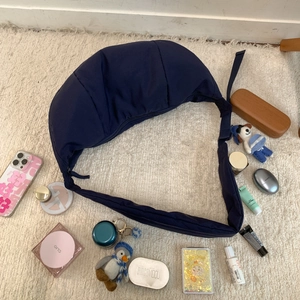 Flat lay of navy blue nylon crescent bag on rug showing spacious interior capacity