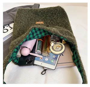 Detail view of large moss green plush tote with checkered lining and spacious interior