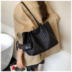 Detail of the black woven tote bag texture with a matching small flap coin purse attachment