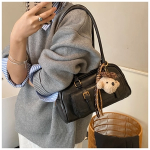 Mirror selfie showing the black leather Boston bag with a cute plush bear pendant accessory