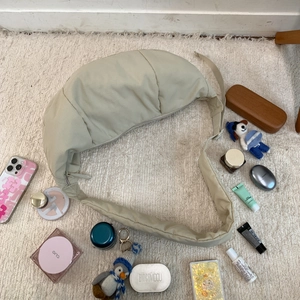 Detailed top view of large nylon crescent bag with wide padded strap on white carpet