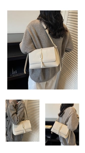 Detail showing the creamy white leather texture and elegant metallic buckle of the bag