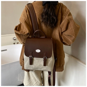 Detailansicht des zweifarbigen Vintage-Rucksacks mit Lederklappe und Hasen-Emblem vorne