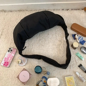 Nylon crescent bag showing storage capacity with phone, cosmetics and everyday essentials