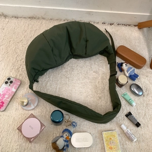 Macro view of dark green quilted nylon crescent bag showing spacious interior capacity