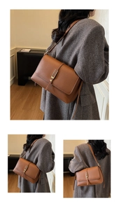 Close-up of brown litchi grain leather shoulder bag with vintage gold vertical metal buckle