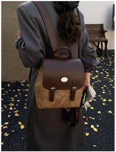 Vintage-Rucksack in Gelb und Braun, draußen getragen an einem Herbsttag mit Ginkgoblättern
