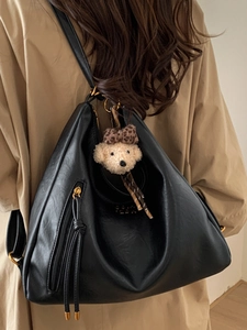 Minimalist black PU leather tote bag with gold zipper and plush bear charm accessory