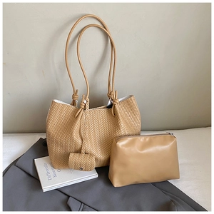 Detailed view of khaki woven tote bag with matching inner pouch and knotted charm accessory