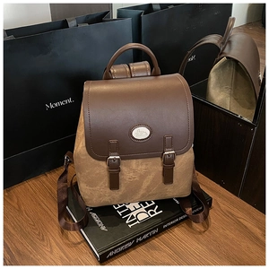 Detailansicht eines Vintage-Rucksacks mit Lederklappe und Schnallen auf Büchern