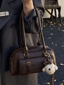 Brown faux leather bowling bag with gold buckle and cute plush bear charm for autumn