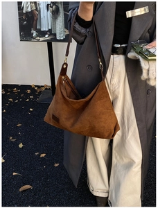 Gros plan d'un cabas en daim marron avec bandoulière en cuir et boucle dorée